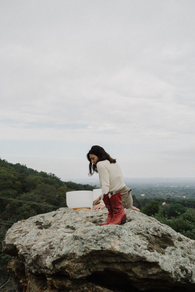 Femme méditant avec un bol en cristal de quartz, séance de thérapie sonore pour l’harmonie et la guérison vibratoire.